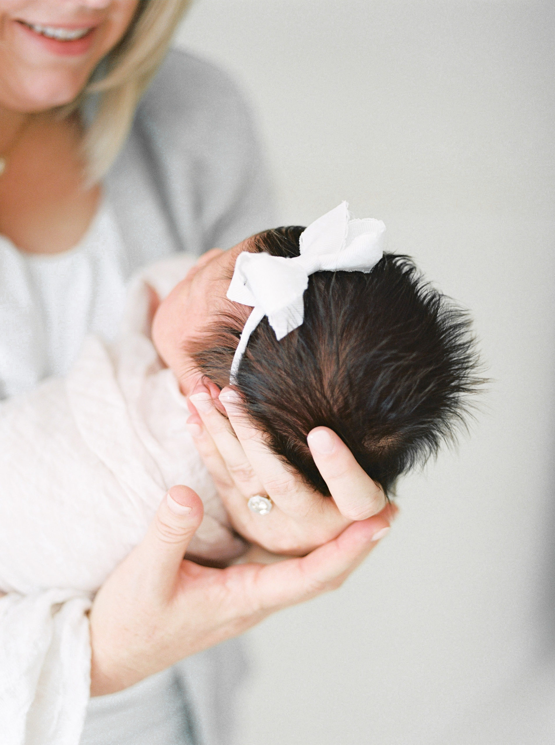 Little Rock Arkansas Newborn Photographer | Mom holding baby girl in studio